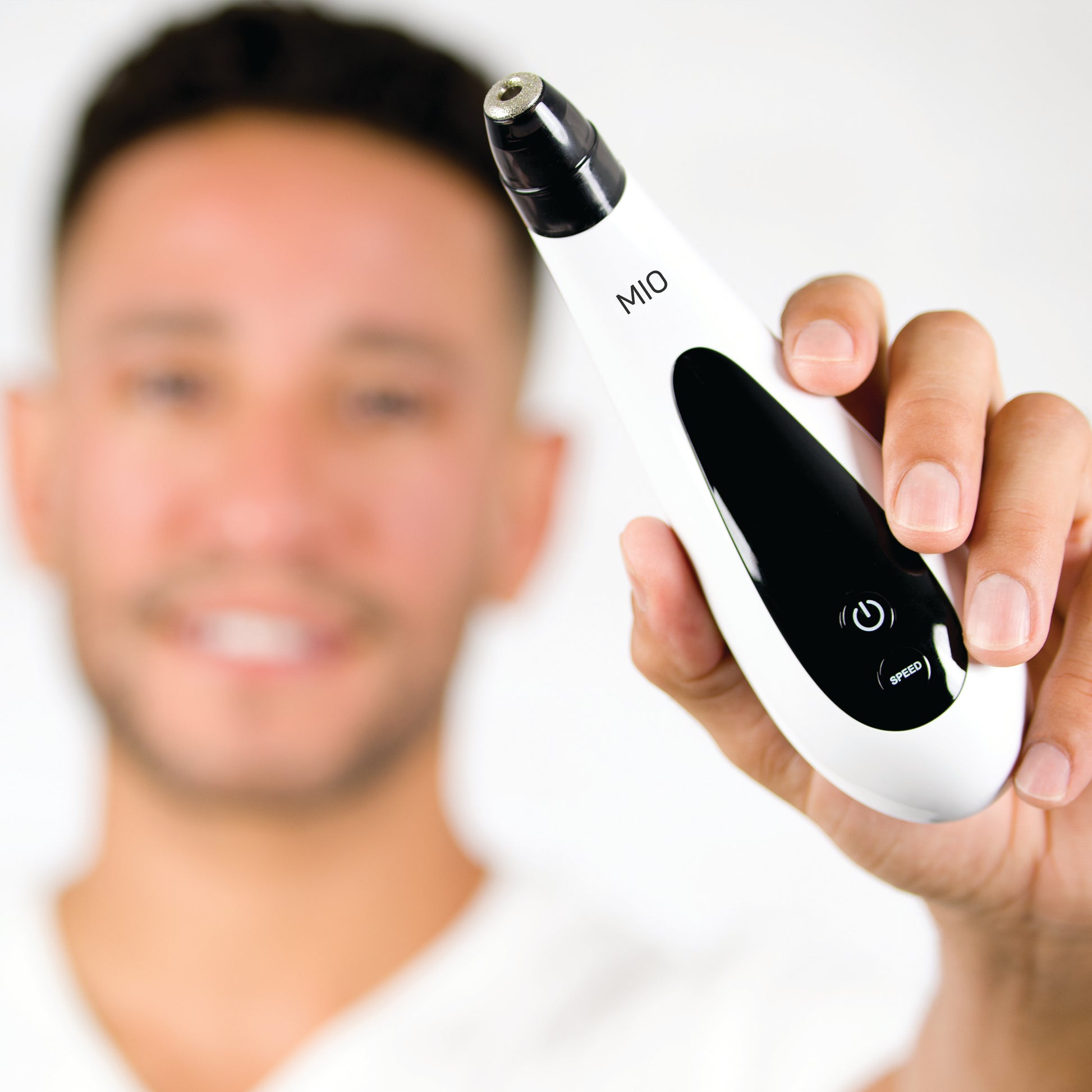A man holding up a Spa Sciences MIO BUNDLE - BONUS Diamond Replacement Tip used for microdermabrasion.