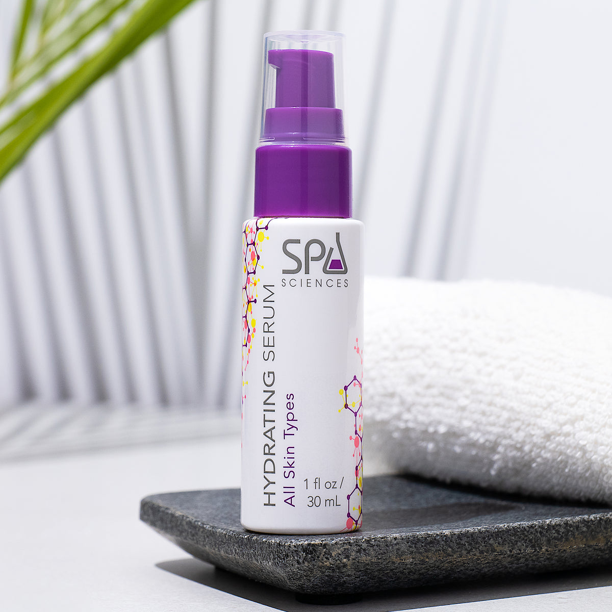 A bottle of Spa Sciences Retinol Renewal Kit (Dry Skin) serum with a purple pump dispenser, standing on a grey stone tray next to a white towel.