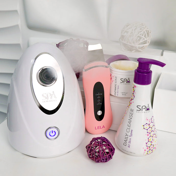 A collection of Spa Sciences' Pore Perfection Bundle organic spa skincare products and devices on a white surface.