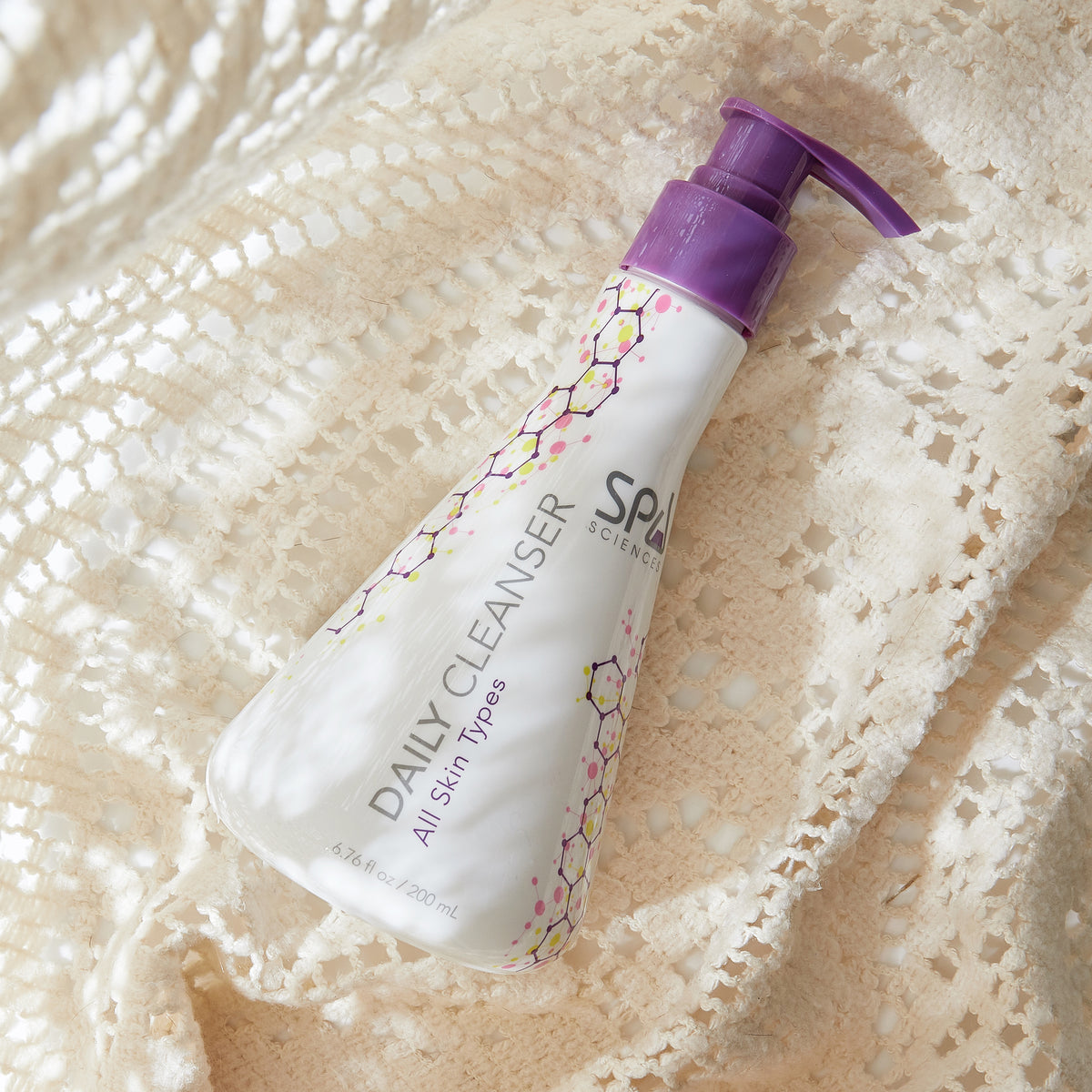 White plastic bottle of Spa Sciences Shine Control System daily cleanser with a purple pump dispenser, featuring a molecular pattern on the label.