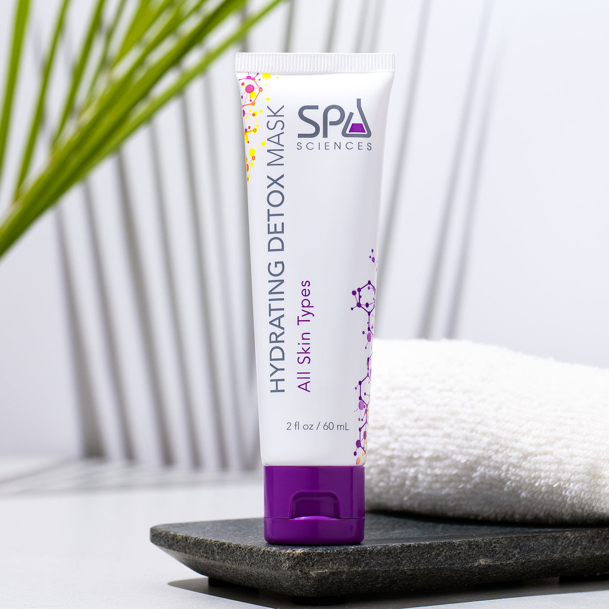 A squeeze tube of Spa Sciences Hydrating Detox Mask from the Skin Cycling Kit (Oily Skin) with a purple cap, sitting on a stone tray.