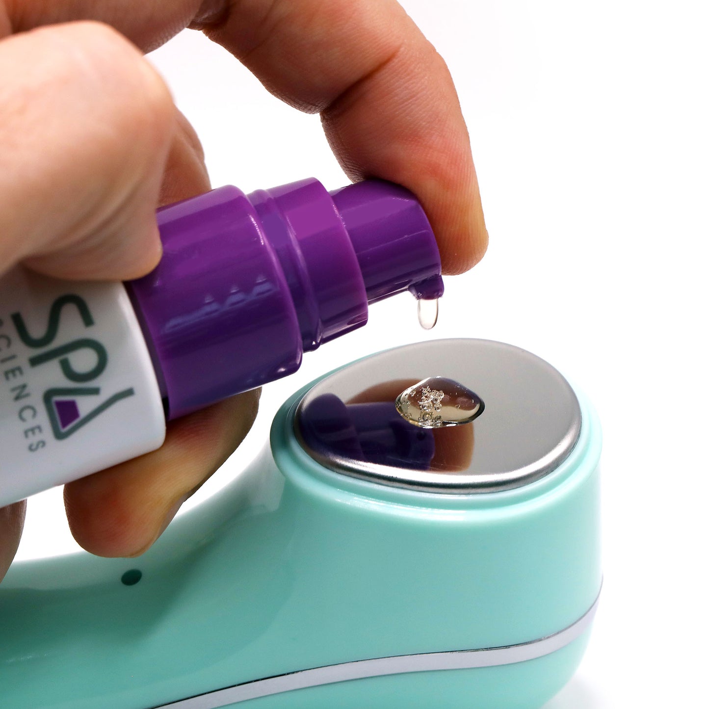 A person is using a Spa Sciences Ultimate Moisture Bundle device to apply a purple liquid.