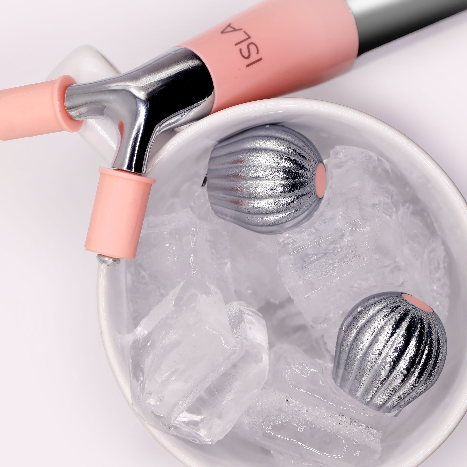 A cup with ice and a Spa Sciences Ultimate Moisture Bundle, featuring a pink and silver object.