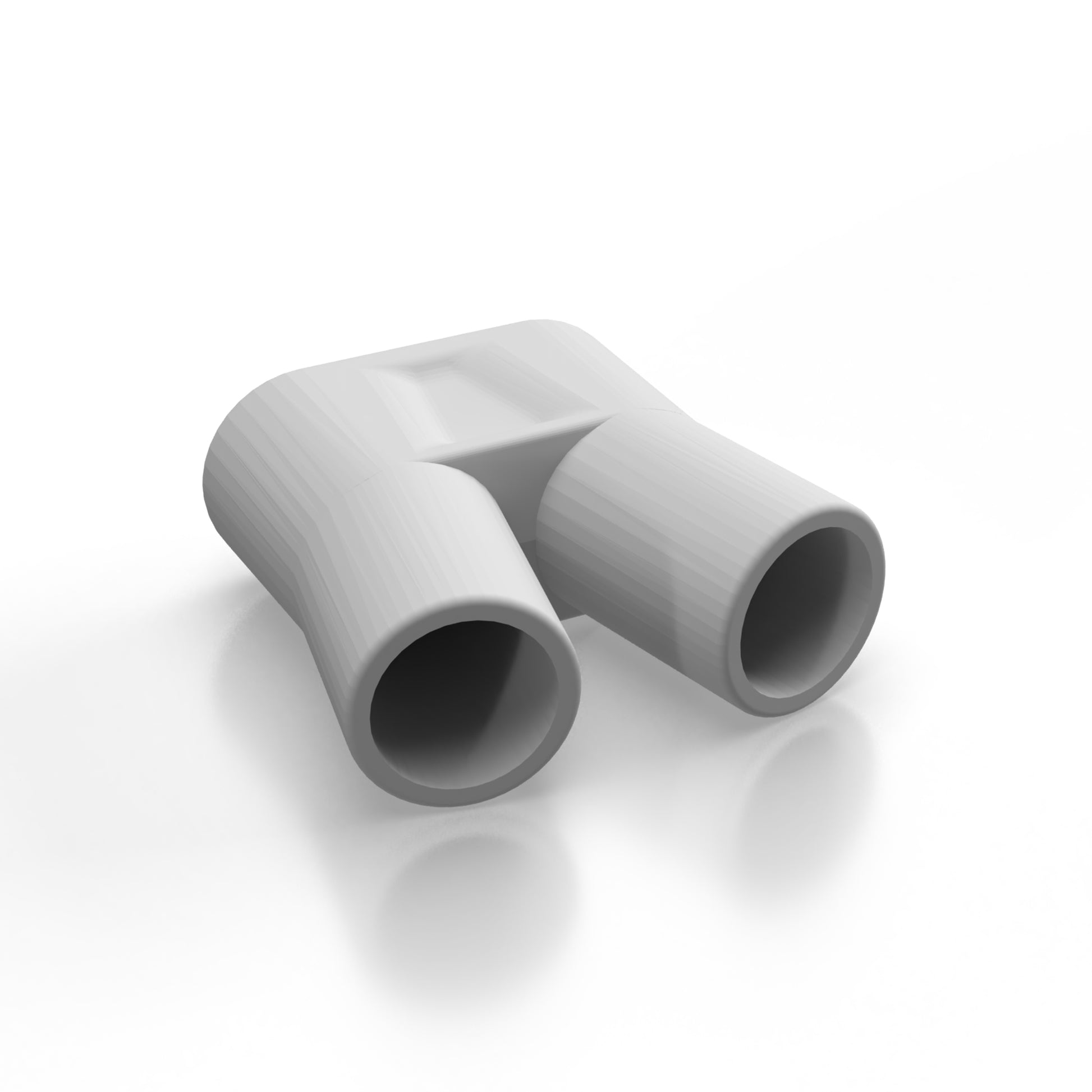 A Spa Sciences Auto Clean Tube accessory, the gray plastic Y-shaped connector with two openings, lies on a pristine white surface.