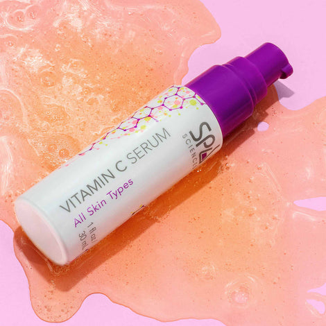 A Spa Sciences Vitamin C Serum surrounded by a pink background.