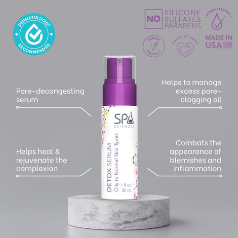 A bottle of Spa Sciences Detox Serum for skin breakouts on a marble table.