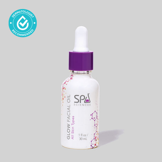 A bottle of Spa Sciences Glow Facial Oil with antioxidants for skin aging on a grey background.