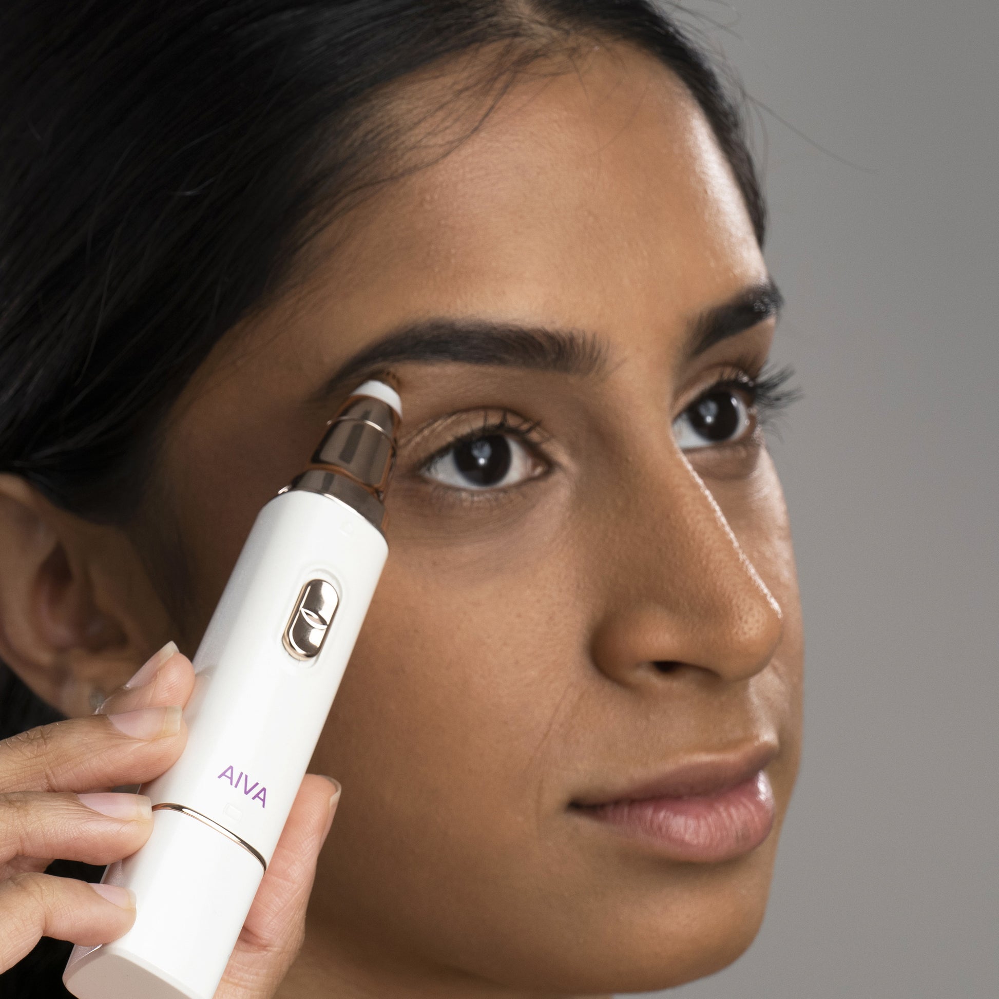 A woman is using the Spa Sciences On the Go Set on her eyebrows.