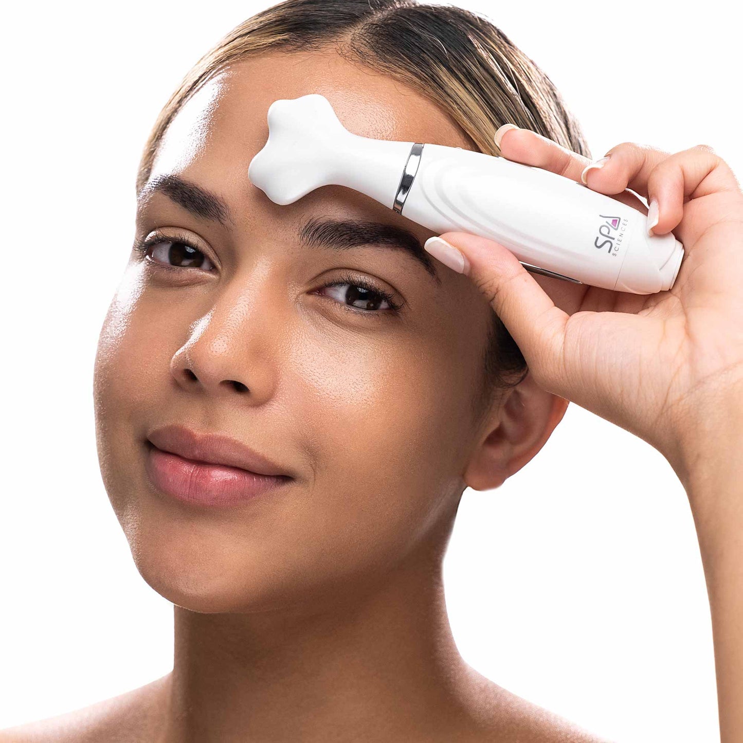 A woman is holding a LORI sonic wand to her eyebrows to promote blood circulation. (Spa Sciences)
