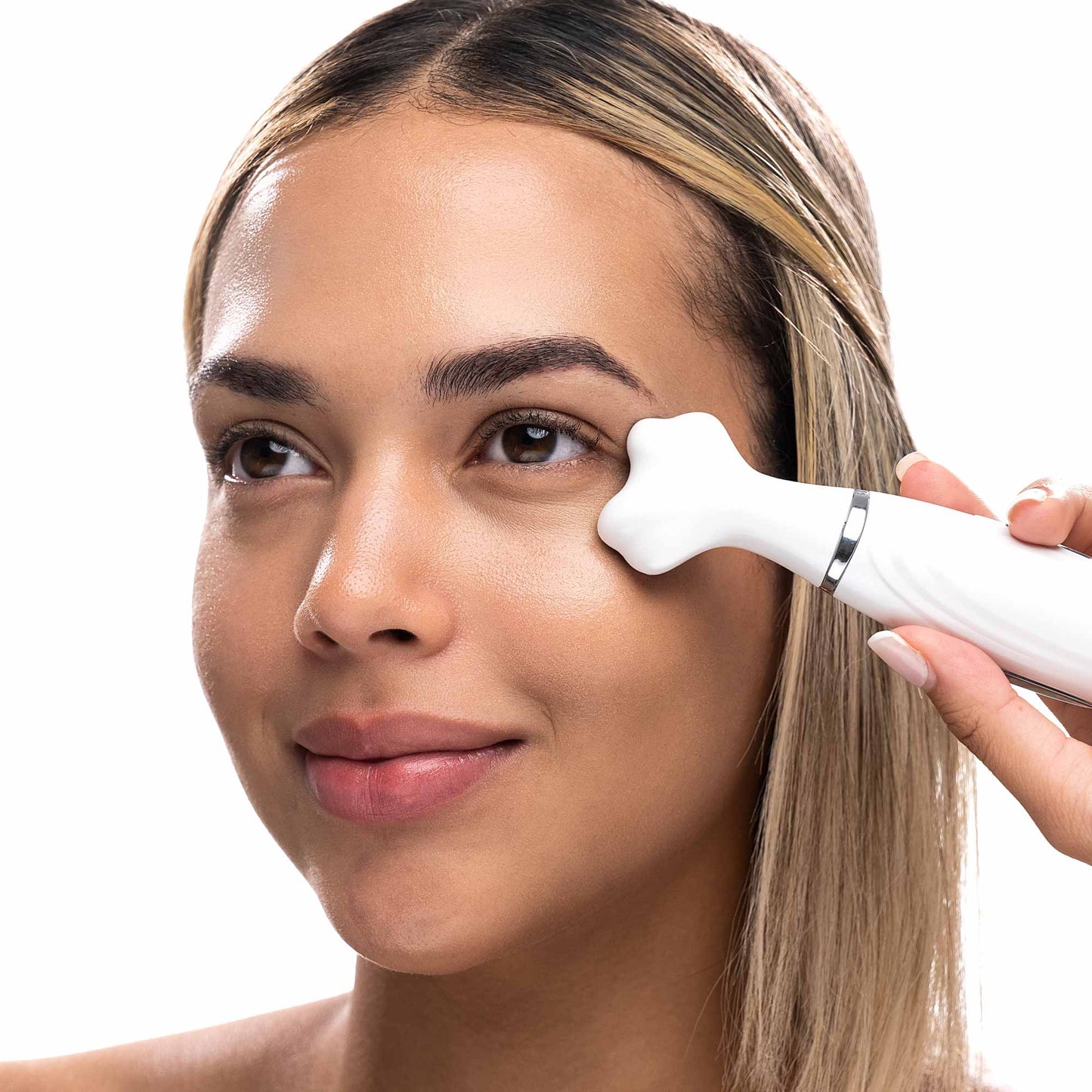 A woman is using a LORI sonic wand by Spa Sciences to promote blood circulation on her face, aiming to minimize fine lines.
