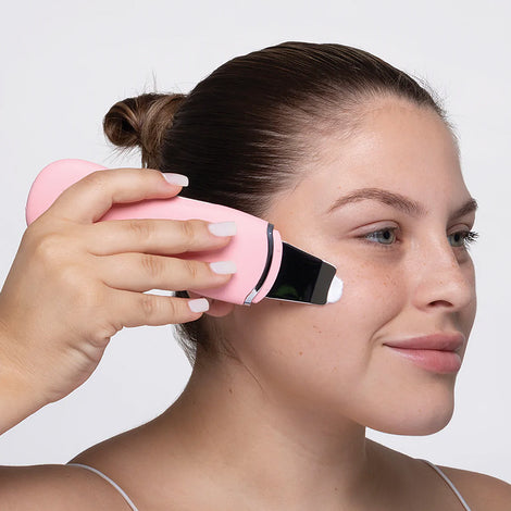 A woman is using the 'Perfect Pores' Set facial cleanser for her Ultrasonic Deep Cleaning routine by Spa Sciences.